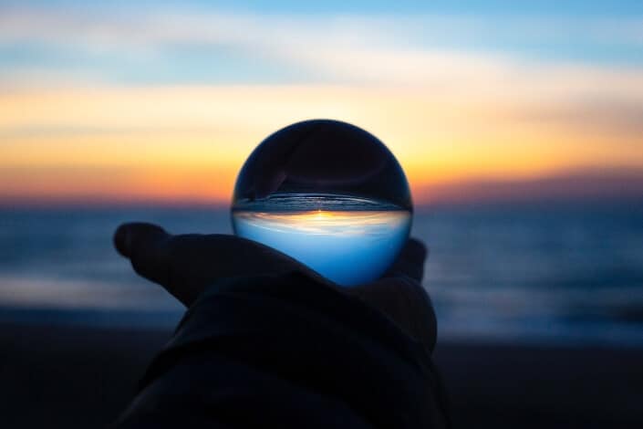 person holding clear glass ball