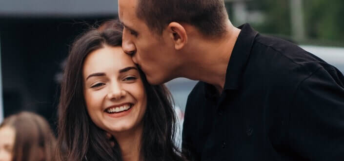 Man kissing girlfriend's forehead