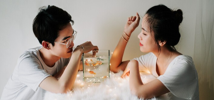 Couple playing with aquarium fishes