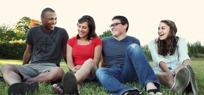 Friends hanging out and sitting on grass