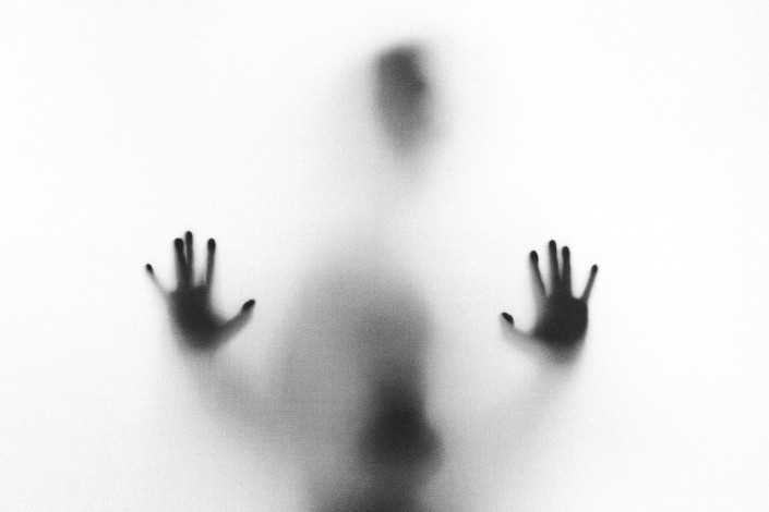 a scary silhouette against a glass pane