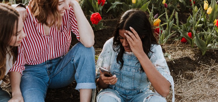 Three girls reading a text and smiling