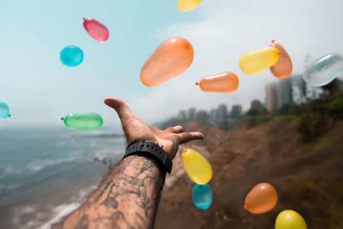 Guy throwing balloons into the air