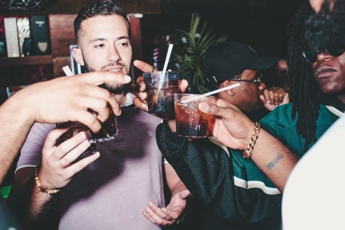 group of friends tossing drinks