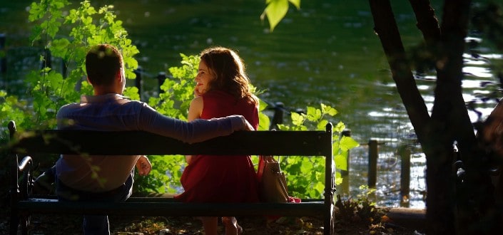 couple sitting on a bench by the river