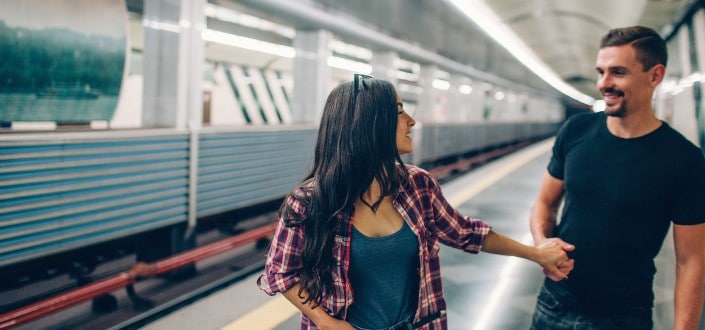 Girl Holding Guy's Hand on Train Station