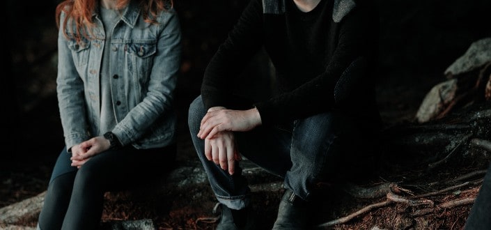 Couple Sitting Beside Each Other on a Tree