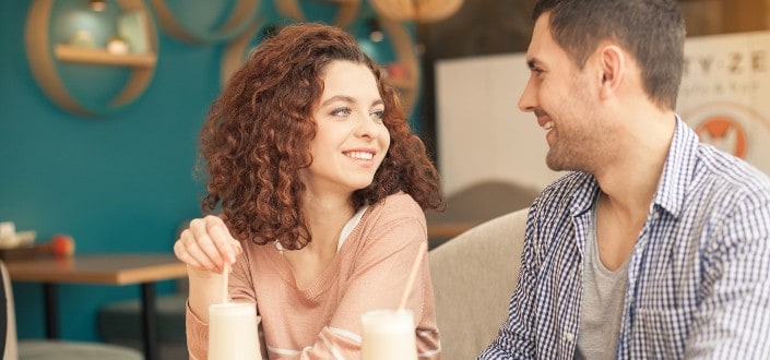 Girl And Guy Smiling at Each Other at a Cafe