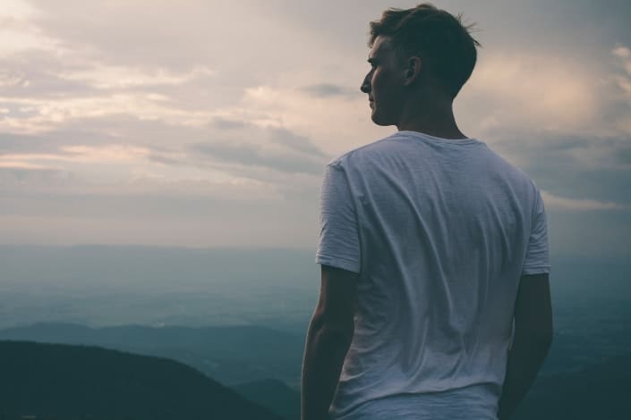 Guy in White Shirt Staring in the Distance Over a Hill