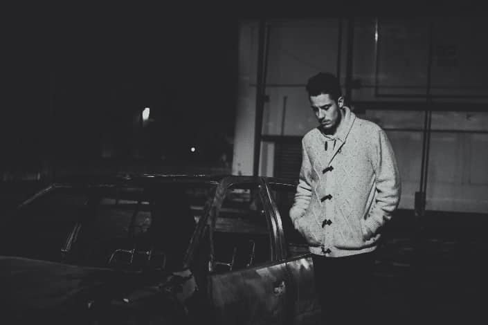 Guy in Solemn Mood Standing Beside a Car