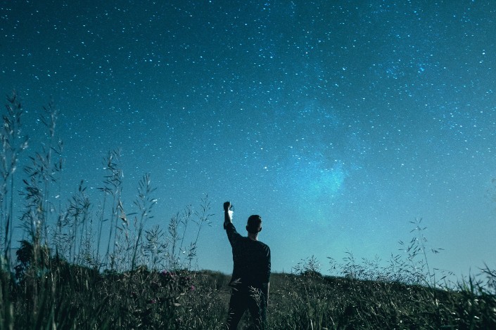 Guy Holding His Hand Up in the Starry Sky