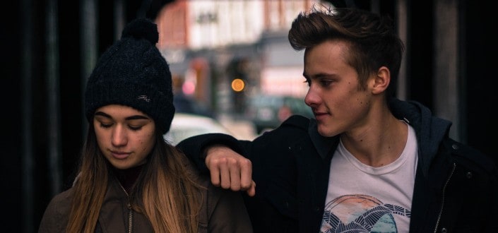 Guy leaning hand on girl's shoulder.
