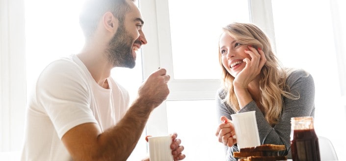 Guy and girl talking over coffee on a bright day.