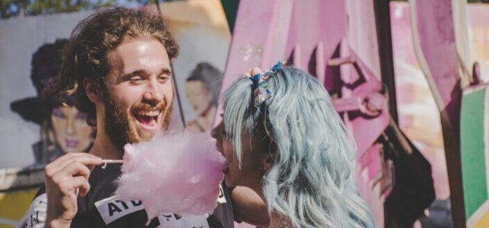man feeding cotton candy to a woman