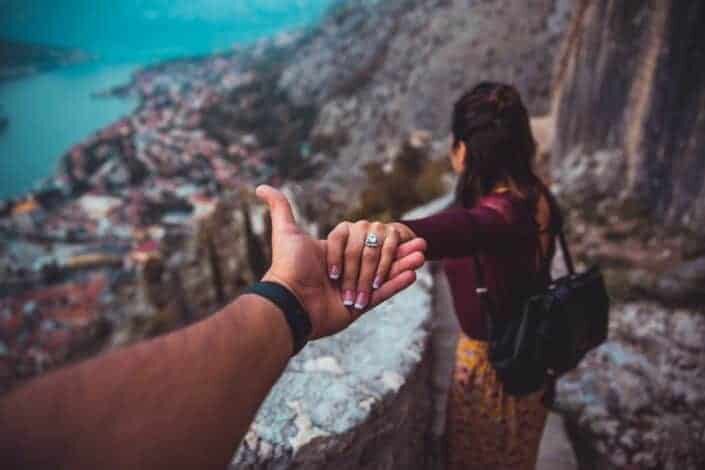 Man holding the hand of the girl descending from the stairs.