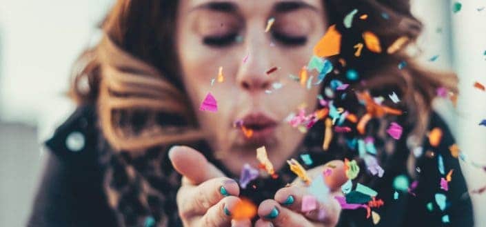 woman blowing paper strips 