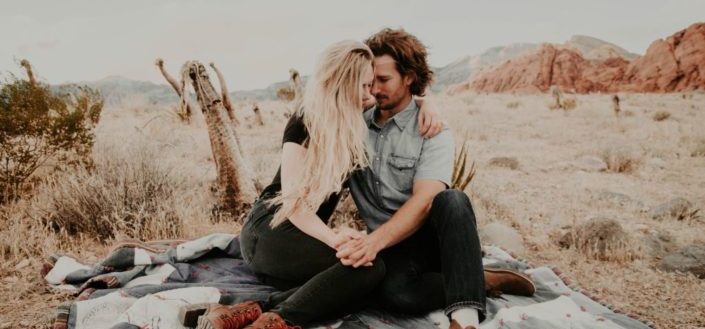couple holding hands at picnic date