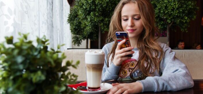 Woman checking on her phone inside a cafe