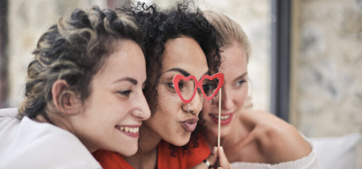 three women sitting closely with each other posing for a shot
