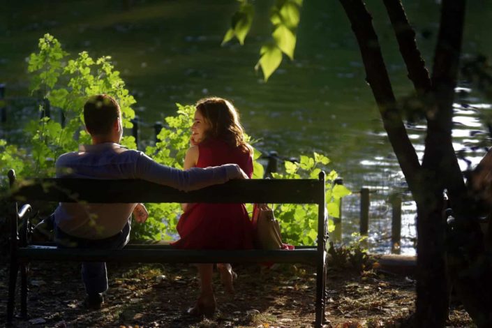 couple sitting on bench beside a lake
