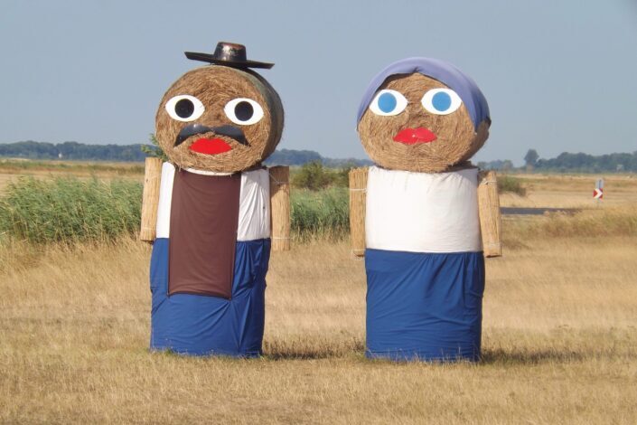 Dressed male and female human haystacks.