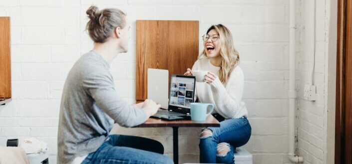 Couple, laughing while doing computer works and having coffee.