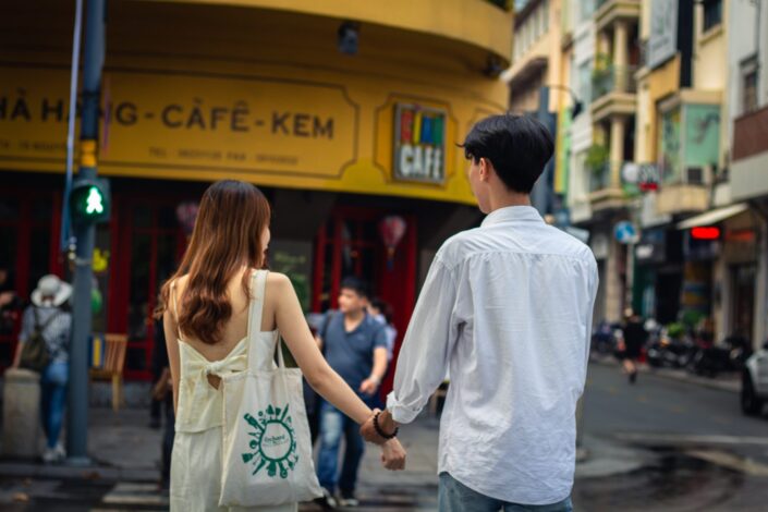 Couple, holding hands while crossing the street.