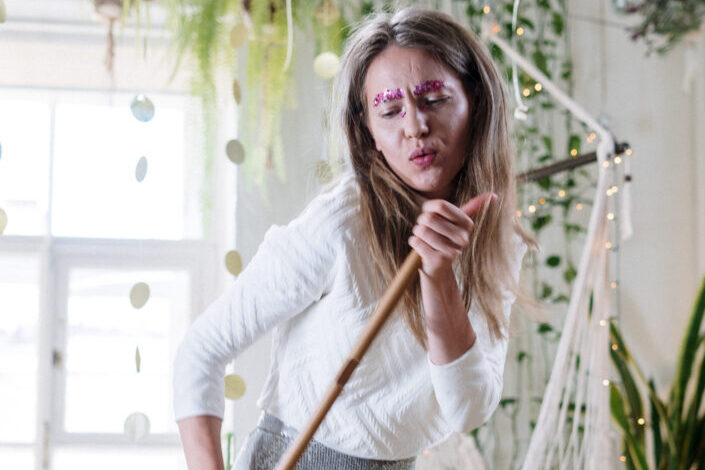 Woman with glittery brows, having fun doing chores.