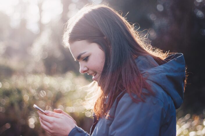 Confused girl, reading a text on her phone.