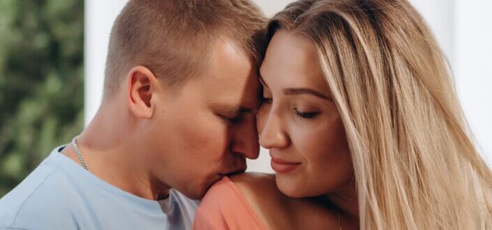 A romantic man kissing her girl's shoulder