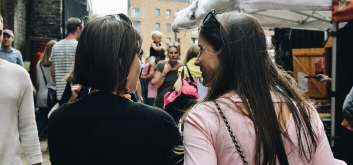 Two women talking while walking together.