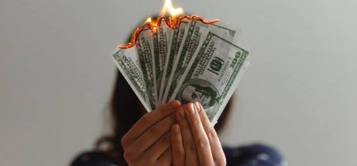 Burning fake dollar bills.
