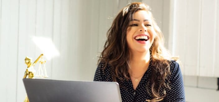Delighted woman in front of her laptop.