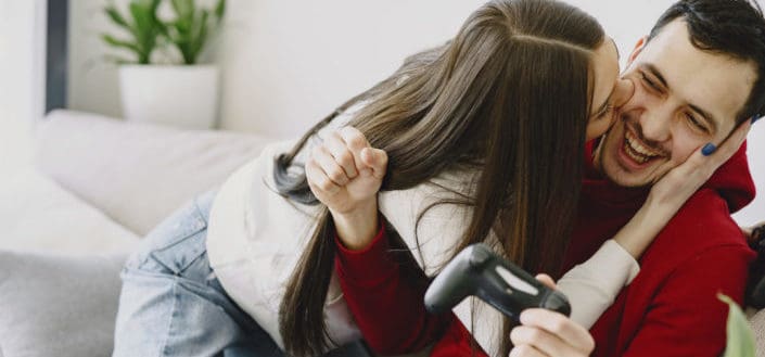 Woman kissing his man while playing games