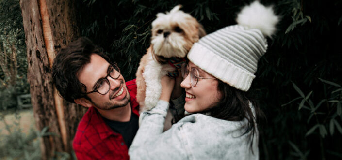 Couple playing with their pet dog outside