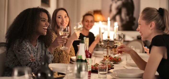 Group of friend gathered on a table sharing foods and stories.