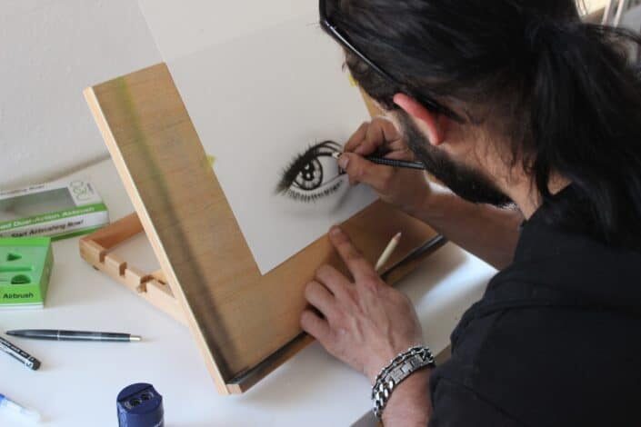 man drawing human eye