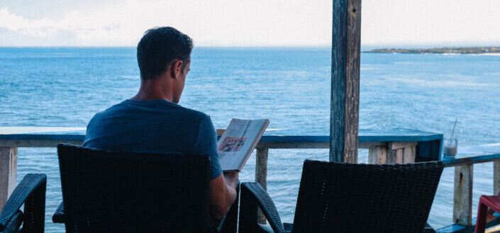 man sitting on a chair overlooking the ocean