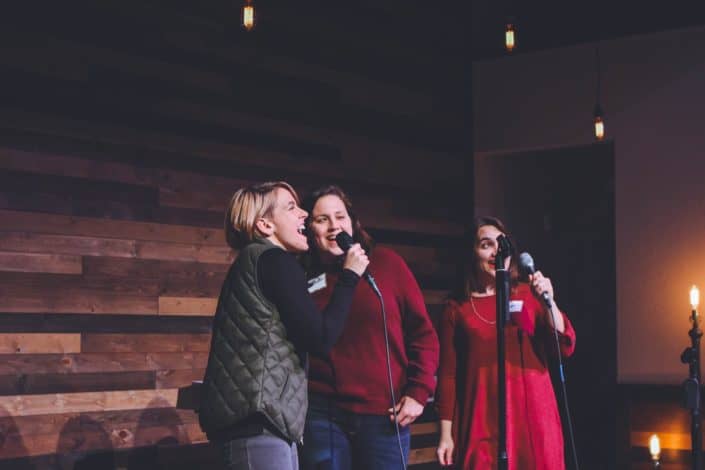 three women singing at karaoke