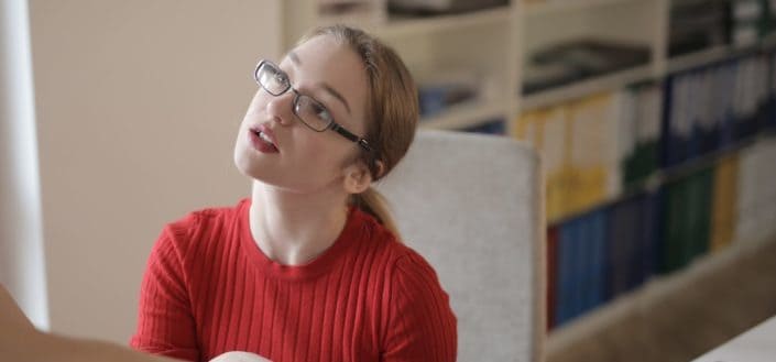 Young girl with glasses looking up