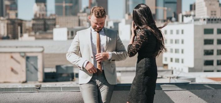 A well-dressed couple standing on a rooftop