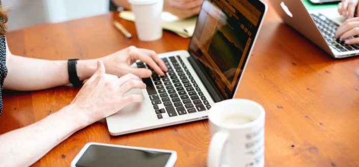 Hands typing on a laptop keyboard