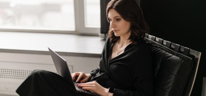 Young woman in chair working on a laptop