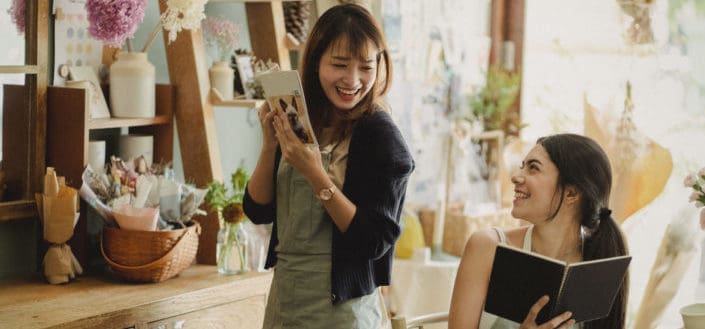 Two girls smiling at each other in a store