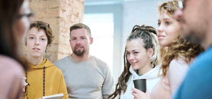 Group of people listening to a woman talking