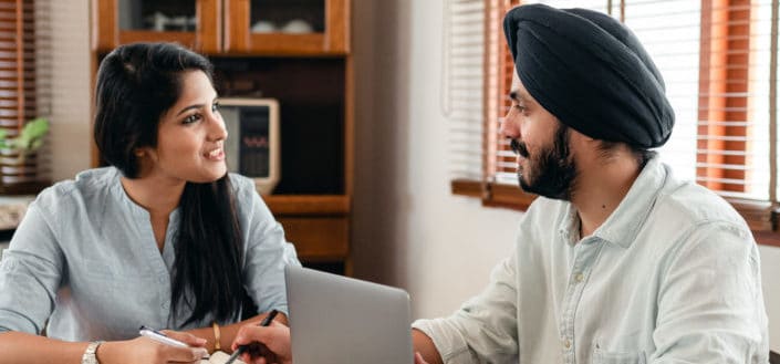 Couple discussing in front of a laptop