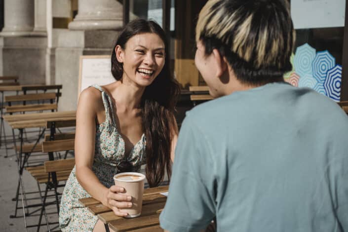A couple laughing outside a cafe