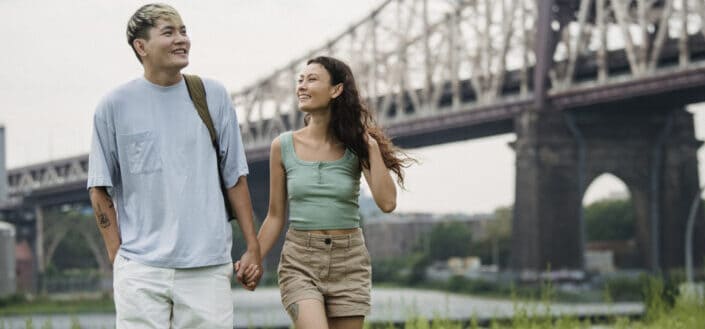 A couple walking under a bridge