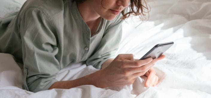 woman in her bed chatting to someone