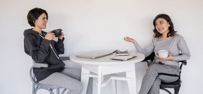 Two women chatting while having a coffee.